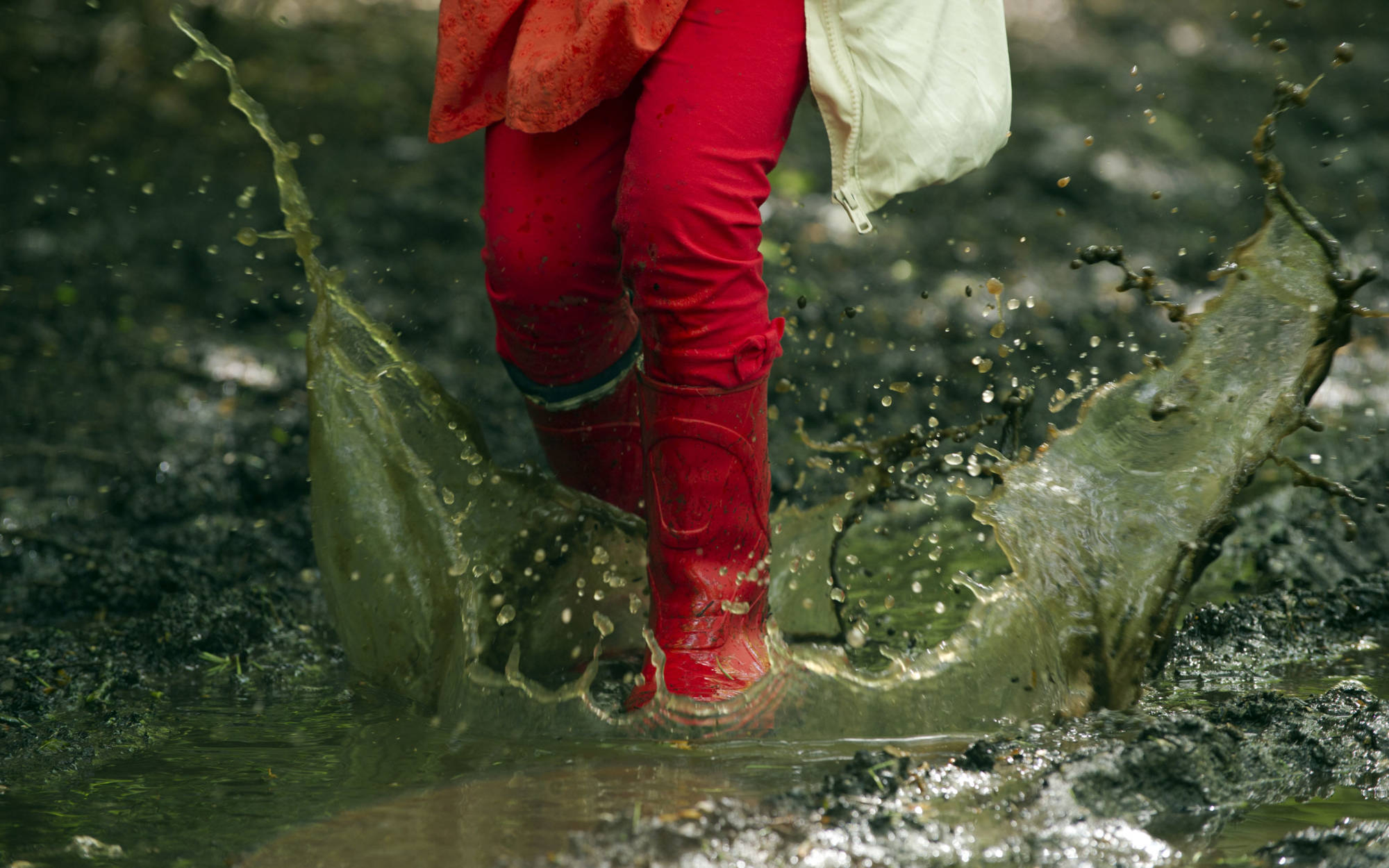 young girl splasing in a puddle