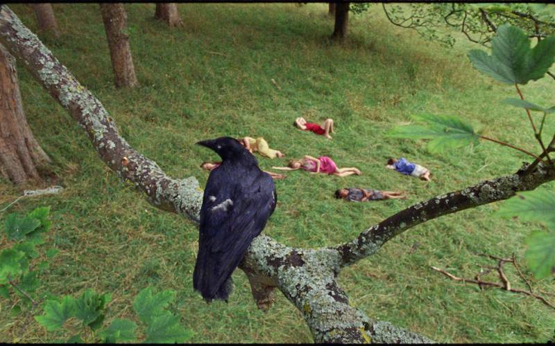 Still from film with crow and five children asleeep in the garden