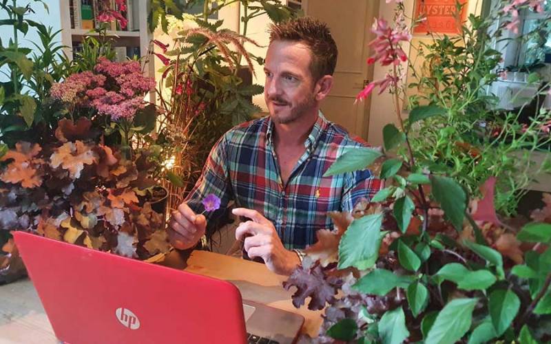 Gardener Nick Bailey sat among house plants