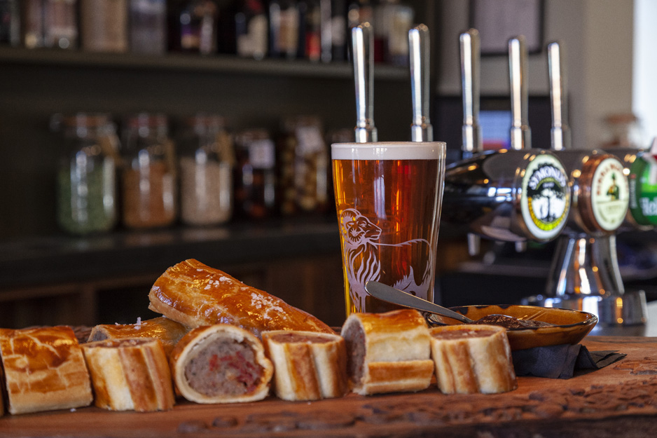 Sausage roll and beer on a bar